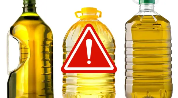 Bottiglie di olio di oliva con un cartello di pericolo. Attenzione all'olio di oliva lampante, potrebbe non essere quello che pensi.