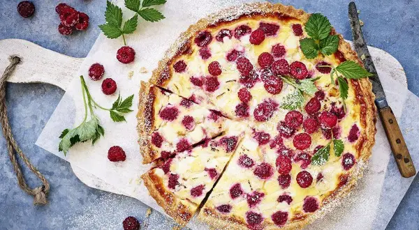 En härlig hallonpaj, perfekt för ett somrigt hallonpaj recept. Garnerad med färska hallon och myntablad.