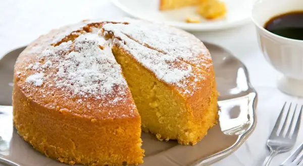 Una deliziosa torta senza glutine, spolverata di zucchero a velo, pronta per essere gustata con un caffè.