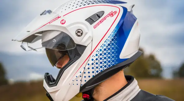Biały kask motocyklowy Scorpion EXO z niebieskimi i czerwonymi detalami, zapięcie DD.