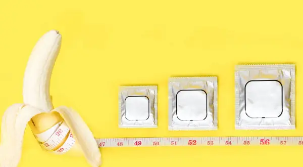 Banana con metro, tre confezioni di preservativi di diverse misure. La taglia XXL corrisponde alla taglia uomo.