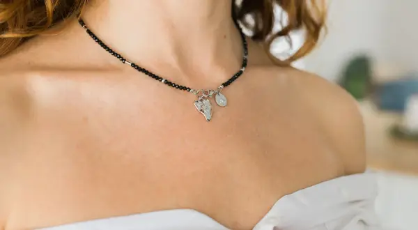 Czarny choker z zawieszkami, idealny dodatek do stylizacji. Co to jest choker? To krótki naszyjnik, który przylega do szyi.