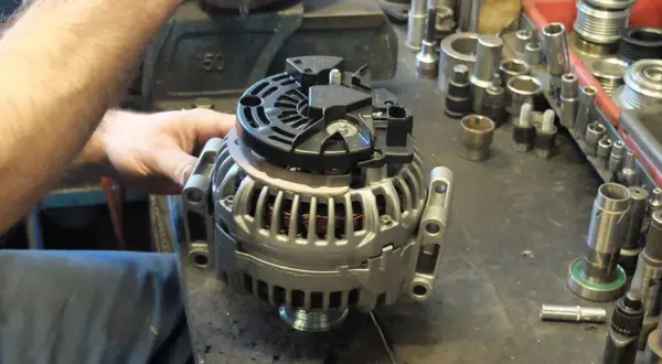 Warsztat samochodowy, gdzie mechanik sprawdza alternator. Dowiedz się, ile kosztuje regeneracja alternatora i jakie części są potrzebne.