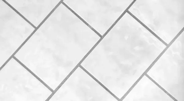 Białe, błyszczące płytki ułożone w geometryczny wzór. Precyzyjna rektyfikacja płytek zapewnia idealnie równe fugi.