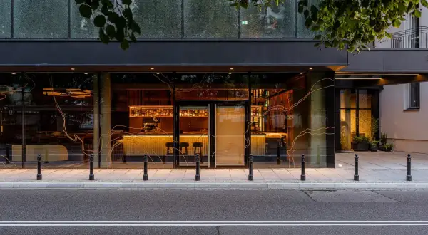 Elegancki bar i restauracja w hotelu Nobu Warszawa, widoczne przez duże okna.