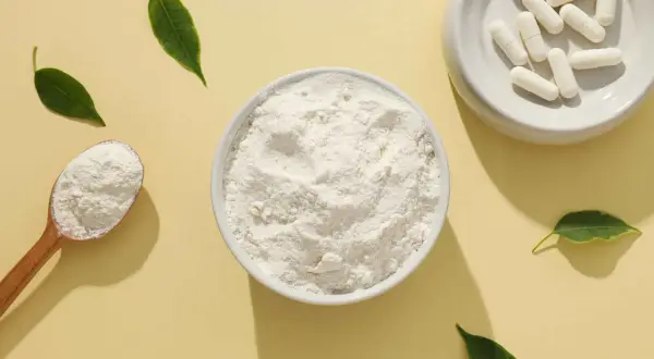 Schale mit kollagenpulver, Löffel und Kapseln. Kollagenpulver sinnvoll für Haut und Gelenke.
