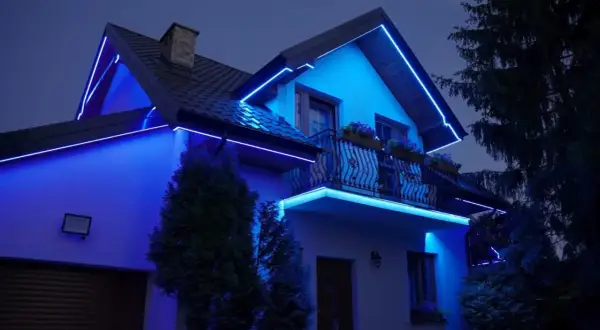 Dom oświetlony niebieską listwą RGB, podkreślającą jego architekturę.