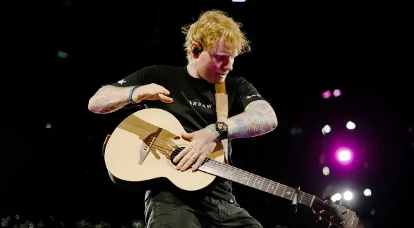 Ed Sheeran gra na gitarze, wykonując swój największy przebój na koncercie w Warszawie.