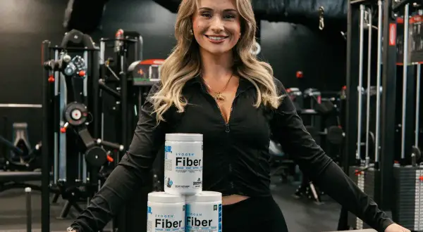 Fitness-Fan mit drei Dosen Evogen Fiber. Diese Produkte helfen, den Körper mit Ballaststoffen zu versorgen, ohne viele Kalorien zu haben.