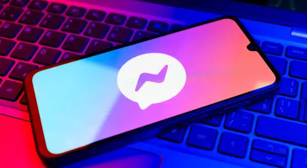 Telefon z logo Messengera na klawiaturze. Dowiedz się, jak zmienić hasło na Messengerze, aby zwiększyć bezpieczeństwo.