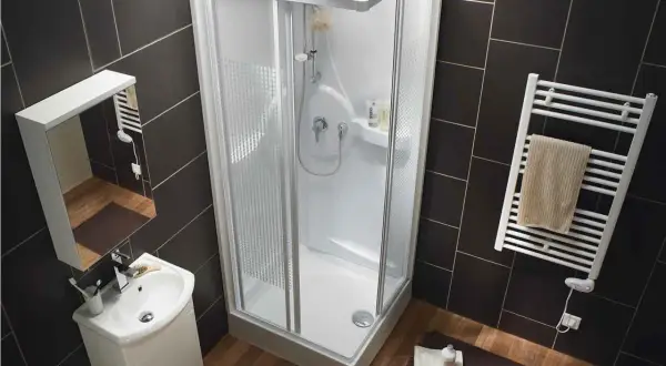 Salle de bain moderne avec douche d'angle, lavabo et sèche-serviettes. La dimension douche standard est bien représentée.