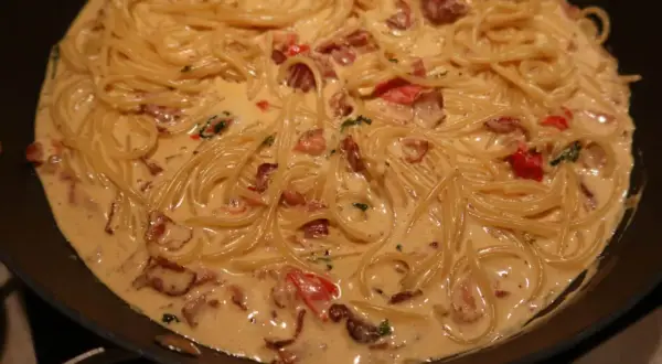En krämig pasta med knaprigt bacon och tomater i en panna. Enkel och god vardagsmat.