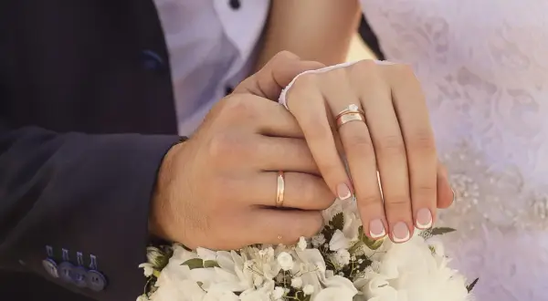 Manos entrelazadas con anillos de matrimonio. En España, el anillo de matrimonio se pone en la mano izquierda.