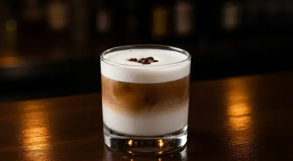 En krämig White Russian med kaffebönor på toppen, perfekt för en mysig kväll.