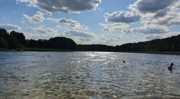Słoneczny dzień nad jeziorem w Złotnikach Kujawskich. Kąpiel w chłodnej wodzie, otoczonej zielonym lasem, to idealny relaks.
