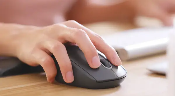 En hand använder en datormus. Kanske letar personen efter information om vad kostar teoriprov.