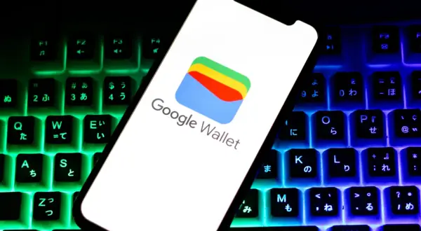 Smartfon z logo Google Wallet na tle podświetlanej klawiatury. Czy portfel Google jest bezpieczny? Odpowiedź znajdziesz w cyfrowym świecie.