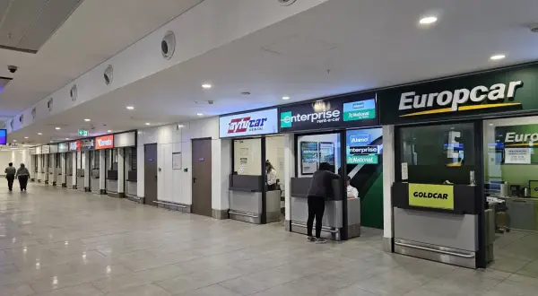 Kasa wypożyczalni samochodów na lotnisku w Antalyi. Widać szyldy Europcar, Enterprise, Avis i innych.