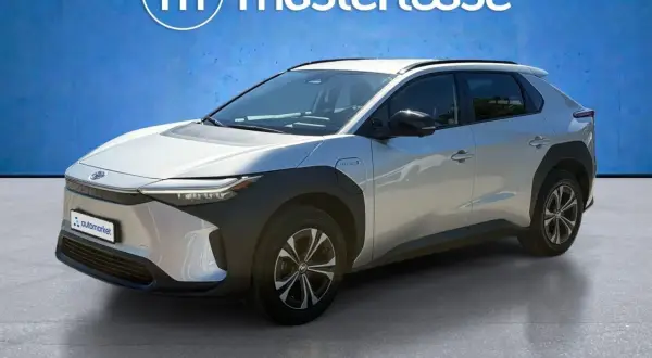 Srebrny Toyota bz4x test na tle niebieskiej ściany z logo Masterlease.