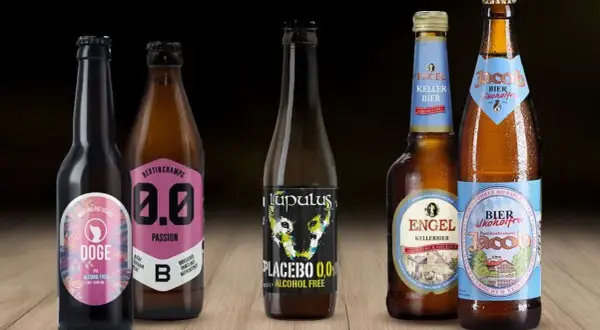 Cinque bottiglie di birra analcolica, tra cui una con etichetta "Doge IPA" e un'altra "Placebo 0,0%", perfette per chi cerca un'alternativa senza alcol, anche se non sono birra 10 gradi.