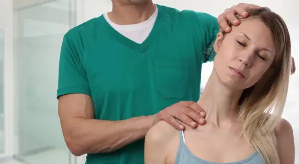 Osteopata co to? Terapeuta delikatnie masuje kark pacjentki, przynosząc ulgę w napięciu.