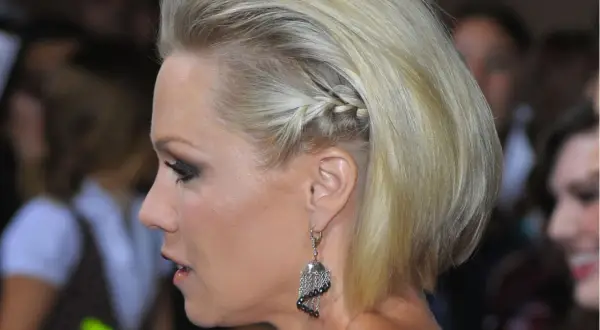 Blonde Frau mit einem seitlichen Zopf, der eine elegante Frisur für kurze Haare darstellt.