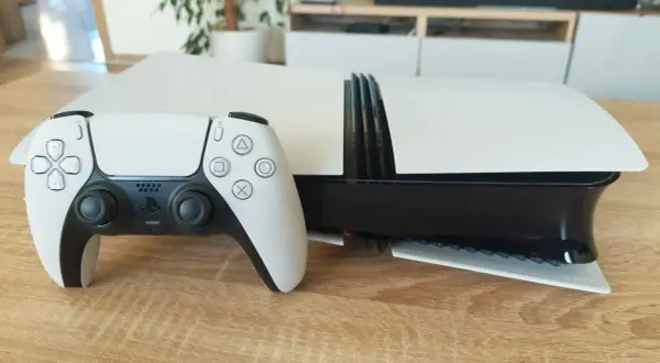 Biały kontroler DualSense obok konsoli PlayStation 5. Czekam na PS5 Pro specyfikacja, by poznać jej możliwości.