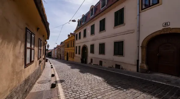 Brukowana uliczka w Zagrzebiu, z kamiennymi domami i latarnią. Odkryj urokliwe zagrzeb atrakcje spacerując tymi uliczkami.