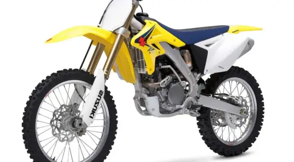 Żółto-biały motocykl enduro z niebieskim siedzeniem na białym tle.
