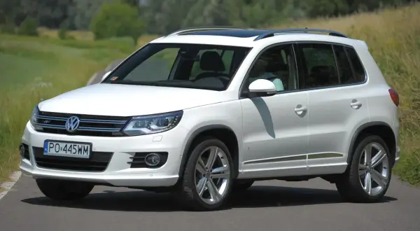 Biały Volkswagen Tiguan na drodze. Sprawdź jego wymiary i możliwości terenowe.