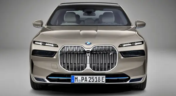 Przód luksusowego BMW Serii 7 w kolorze szampańskim. Charakterystyczny grill, smukłe reflektory LED. Szczegółowe bmw 7 dane techniczne dostępne online.