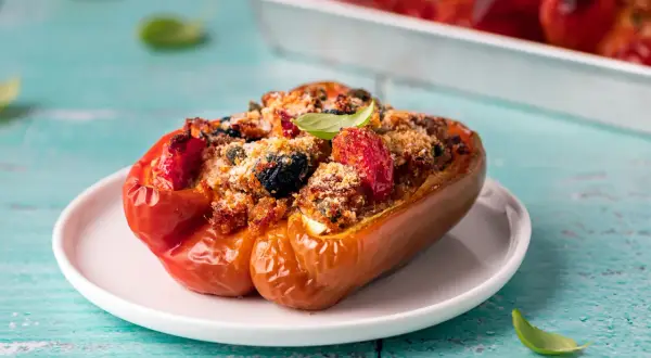 Peperoni ripieni di tonno alla pugliese, un piatto saporito con pomodorini, olive e pangrattato croccante.