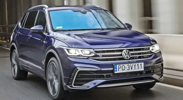 Granatowy Volkswagen Tiguan 2019 pędzi po drodze, jego reflektory LED oświetlają trasę.
