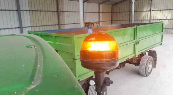 Pomarańczowe światło ostrzegawcze na ciągniku, zgodnie z przepisami, sygnalizuje gotowość do pracy.