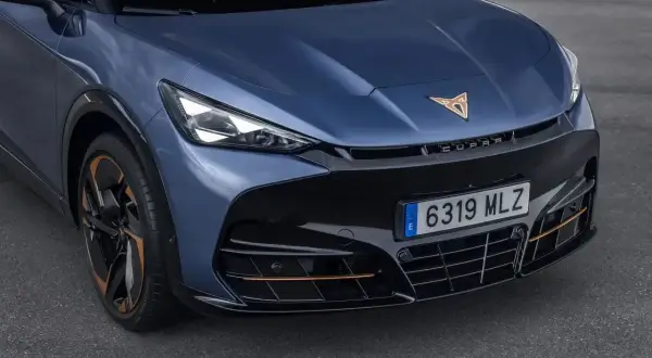 Niebieski Cupra Tavascan z miedzianymi akcentami i sportowym wyglądem.