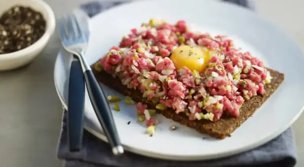 En läcker råbiff på mörkt bröd med en gul äggula i mitten. Perfekt för dig som söker ett gott råbiff recept.