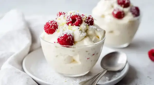 Lätt och fluffig vispad pannacotta tårta med färska hallon och kokosflingor. En perfekt sommardessert.