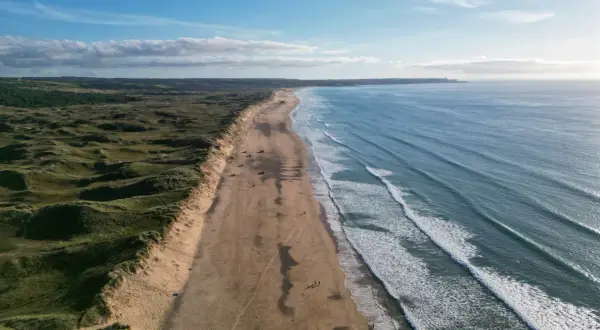 Weite Sandstrände und sanfte Dünen, ideal für mai reiseziele. Die Wellen des Ozeans laden zum Surfen ein.