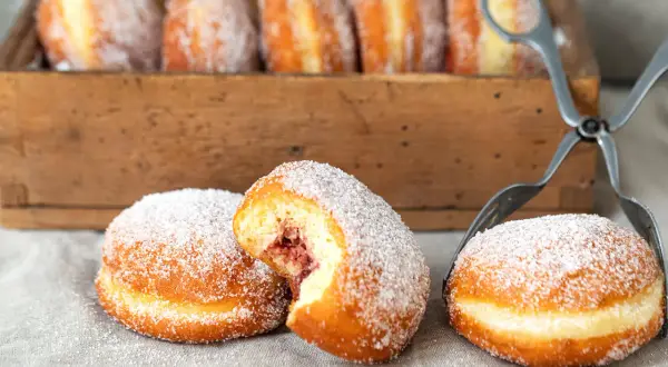 Frisch gebackene Berliner, mit Zucker bestreut, warten auf ihre Füllung. Ein köstliches berliner rezept.