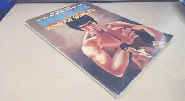 Okładka komiksu "Bruce Lee: Król Kung Fu". Widoczny Popek Franek w kimonie, w pozie bojowej.
