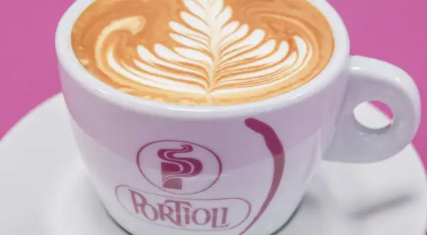 Un cappuccino con latte art a forma di foglia, uno dei tanti tipi di cappuccino che deliziano gli occhi e il palato.
