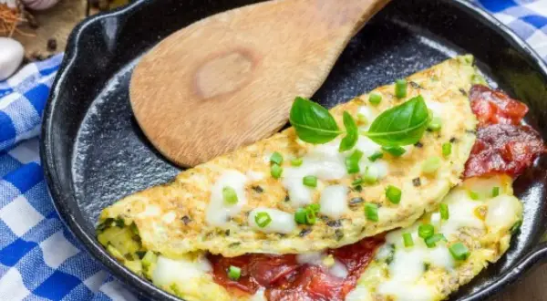 Pyszny omlet z serem, pomidorami i szczypiorkiem na patelni. Idealny omlet przepis na śniadanie.