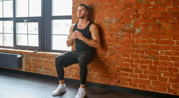 Mann macht Wand-Sit-ups, Teil eines effektiven bodyweight trainingsplan.