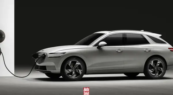 Biały Genesis GV70 na ładowarce. Elegancki SUV z charakterystycznym grillem i podwójnymi światłami.