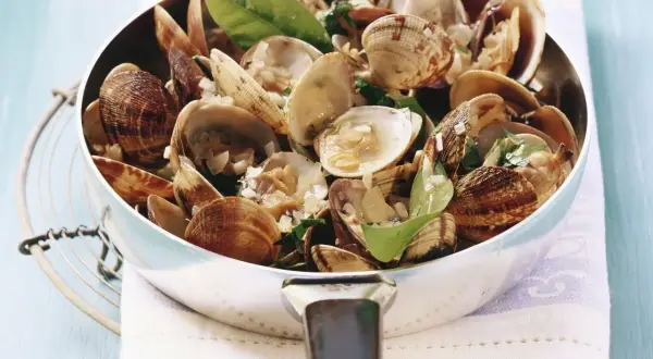 Frisch zubereitete vongole deutsch in einer Pfanne, garniert mit Kräutern und Knoblauch. Ein Genuss!