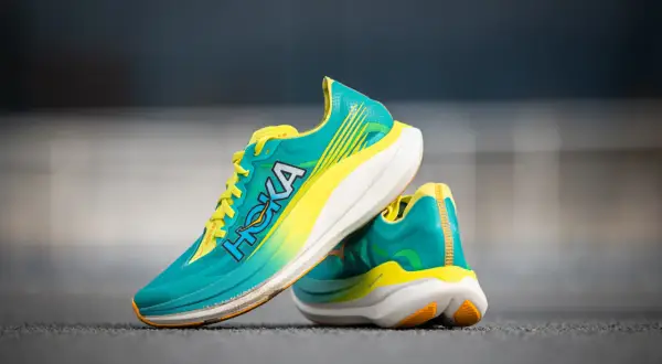 Paire de chaussures de course Hoka Rocket X 2, turquoise et jaune vif, prêtes pour un test de performance.