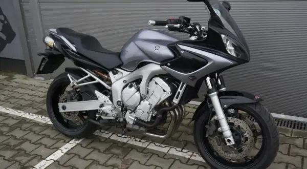 Szary motocykl Yamaha FZ6 z czarnymi akcentami, gotowy do jazdy po miejskich ulicach.