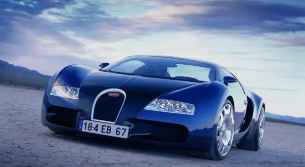 Niebieski Bugatti Veyron na pustynnym tle. Skąd pochodzi ten legendarny samochód? Z Francji, z Alzacji, gdzie narodził się Ettore Bugatti.