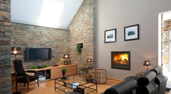 Gemütliches Fernsehzimmer einrichten mit Kamin, Ledersofa und Steinwand.