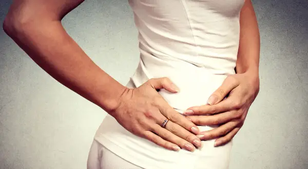 Donna con le mani sull'anca, che esprime dolore anca e ginocchio a riposo.